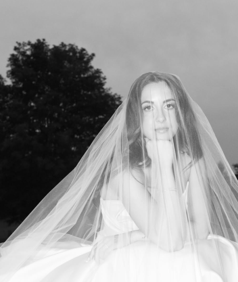 Black-and-white bridal portrait beneath a veil