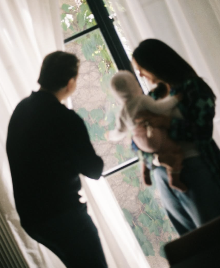 Family together beside a window